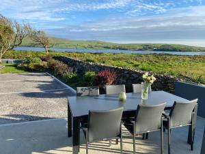 una mesa y sillas con vistas al agua en Cill Bhreac House B&B, en Dingle