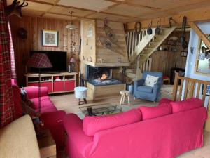 a living room with a red couch and a fireplace at Chalet de 4 chambres avec jardin amenage a Ax les Thermes a 1 km des pistes in Ax-les-Thermes