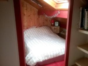 małą sypialnię z łóżkiem w małym pokoju w obiekcie Chalet de 4 chambres avec jardin amenage a Ax les Thermes a 1 km des pistes w mieście Ax-les-Thermes