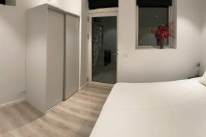 Un dormitorio con una cama blanca y un jarrón de flores en Central kælder lejlighed en Give