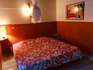 1 dormitorio con 1 cama con edredón rojo en HUAHINE - Bungalow Tiare en Fare