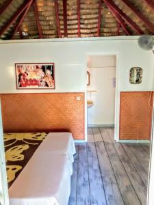 Zimmer mit einem Bett in einem Zimmer in der Unterkunft HUAHINE - Bungalow Pitate in Fare