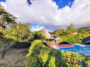 uma vista para um resort com uma piscina em HUAHINE - Bungalow Pitate em Fare
