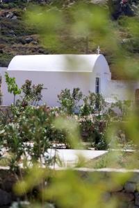 a white building with a cross on the side of it at Archon Seaside Retreat in Plaka