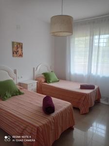 dwa łóżka w białym pokoju z dwoma łóżkami w obiekcie Apartamento Hacienda San Manuel w Marbelli