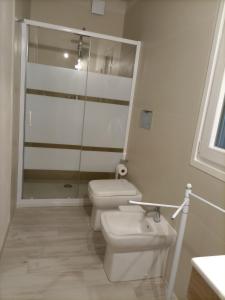 La salle de bains blanche est pourvue de toilettes et d'un lavabo. dans l'établissement Casa Opuntia Rosolini, à Rosolini