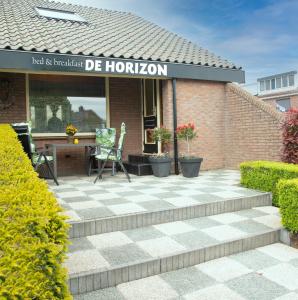 a brick building with a patio with a table and chairs at B&B De Horizon in Urk