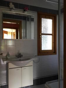 łazienka z umywalką i lustrem w obiekcie Ferienwohnung Orchidee w mieście Kössen