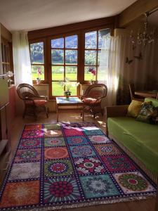 a living room with a rug on the floor at Ferienwohnung Orchidee in Kössen