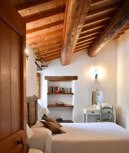 a bedroom with white walls and wooden ceilings and a bed at Palazzo Di Bagnaia in Castel del Piano +48 photos