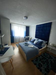 sypialnia z dużym łóżkiem z niebieskim zagłówkiem w obiekcie Pokoje u Camili w Rewie