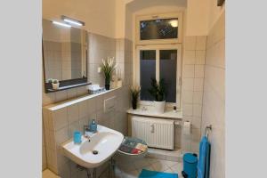 ein Bad mit einem Waschbecken und einem Spiegel in der Unterkunft Holiday apartment in Leipzig