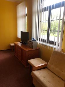 Zimmer mit einem TV und einem Schreibtisch mit Stuhl in der Unterkunft Apartmán na čerpací stanici RoBiN OIL Rýmařov in Rýmařov
