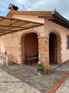 un patio con un banco en una casa en CASA ALBERELLO, en Torrita di Siena
