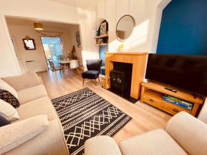 a living room with a couch and a flat screen tv at 3 Bed House with Garden near Weymouth Beach in Weymouth