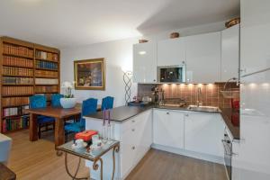 cocina con armarios blancos y comedor en Maison d'une chambre avec jardin clos et wifi a Belloy en France, en Belloy-en-France