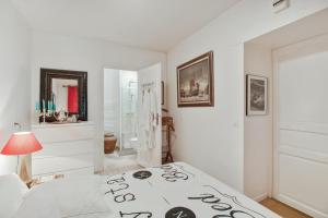 Dormitorio blanco con cama y lámpara en Maison d'une chambre avec jardin clos et wifi a Belloy en France, en Belloy-en-France