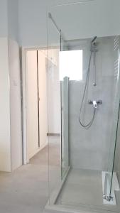 W łazience znajduje się prysznic ze szklanymi drzwiami. w obiekcie Belvárosi ház gyönyörű panorámával w mieście Balatonalmádi