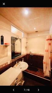 y baño con lavabo, espejo y bañera. en Center Hostel and Tours en Ereván