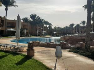 una piscina en un complejo con palmeras en Chalet at Stella Di Mare Makadi Bay en Hurghada
