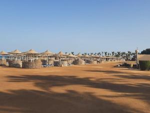 um campo de terra com um grupo de edifícios e palmeiras em Chalet at Stella Di Mare Makadi Bay em Hurghada