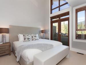 ein weißes Schlafzimmer mit einem Bett und einem Fenster in der Unterkunft Deluxe 3 Level Townhome Private Hot Tub Media Room, Outdoor Living 26 in Whistler