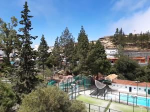 a view of a park with a swimming pool and trees at Apartamento La Cueva, Artenara in Artenara