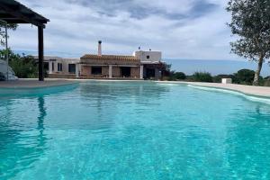 a large swimming pool in front of a house at Villa Casa Limón Formentera in Cala Saona