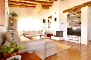 a living room with a couch and a television at Villa Casa Limón Formentera in Cala Saona