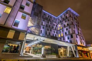 un edificio con una tienda delante de él por la noche en Urban Green Hotel & Suites, en San José