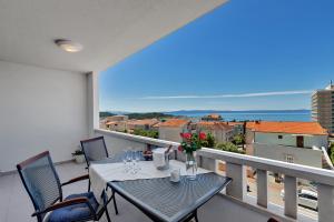 a balcony with a table and chairs and a view of the ocean at Apartments Dany in Makarska