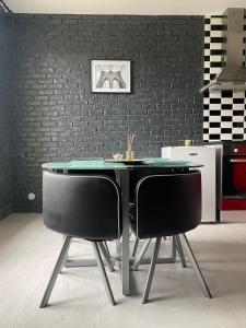 a dining table and two chairs in a kitchen at Verdun in Mantes-la-Jolie