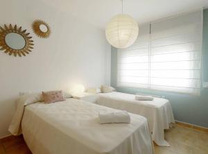 een slaapkamer met twee bedden en een spiegel aan de muur bij Villa con piscina privada in Calpe