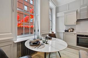 倫敦的住宿－GERRARD PLACE by Q Apartments，白色的厨房,配有桌子和窗户