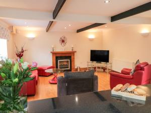 sala de estar con muebles de color rojo y chimenea en St Hilda's Cottage, en Hinderwell