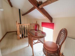 HinderwellにあるSt Hilda's Cottageのテーブルと椅子、窓が備わる客室です。