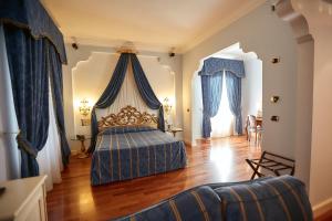 1 dormitorio con 1 cama con dosel azul en Hotel Villa Il Patriarca, en Chiusi