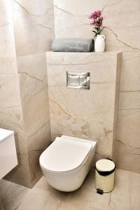 a white toilet in a bathroom with marble walls at VIP Apartament 11 in Lublin