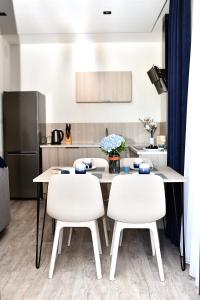 a kitchen with a table and two white chairs at VIP Apartament 11 in Lublin