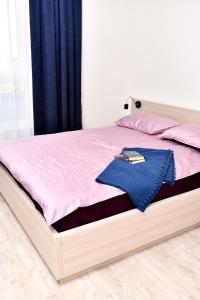 a bed with a wooden frame with a pink blanket at VIP Apartament 11 in Lublin