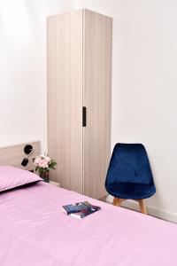 a bedroom with a bed and a blue chair at VIP Apartament 11 in Lublin