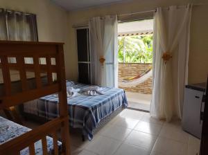 a bedroom with a bed and a sliding glass door at Suítes Carla e Carol in Praia de Araçatiba