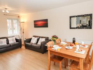 a living room with a table and a couch at Sleeper Cottage in Filey