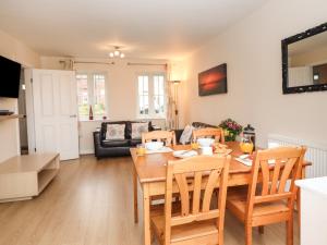a kitchen and living room with a wooden table and chairs at Sleeper Cottage in Filey