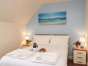 a bedroom with a bed with a bowl of fruit on it at Sleeper Cottage in Filey