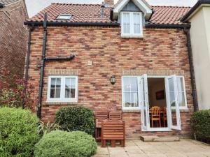 a brick house with two chairs and a table at Sleeper Cottage in Filey