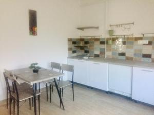 a kitchen with a table and chairs in a room at Lelle-kert Apartman 02 in Balatonlelle