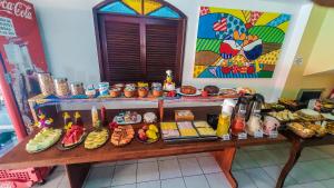 una mesa con muchos tipos diferentes de comida en ella en Pousada Uba-Rio Porto de Galinhas, en Porto de Galinhas