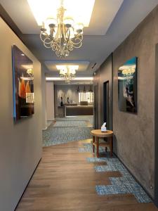 um corredor com um lustre e uma mesa no chão em Nouvel Hôtel du Commerce em Castellane