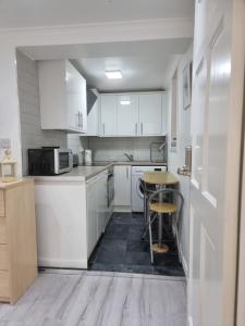 a kitchen with white cabinets and a table in it at Strathbungo Studios in Glasgow